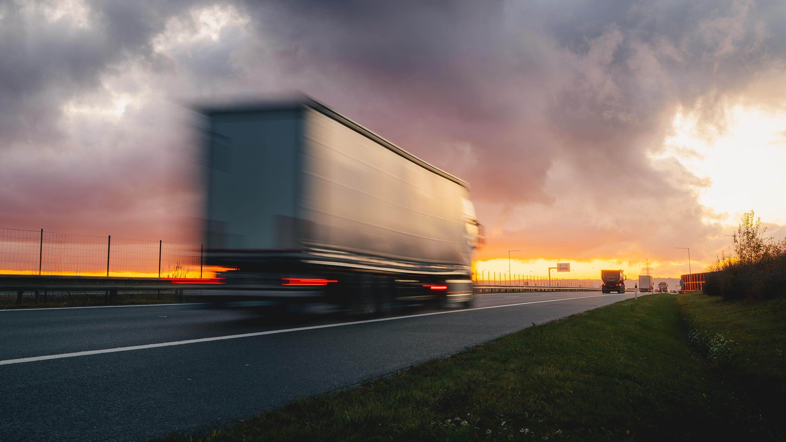 Semi truck in motion on a highway at dusk
